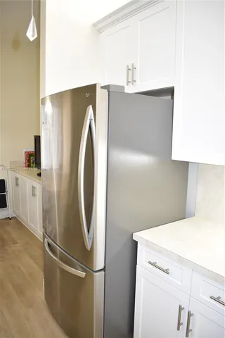a kitchen with stainless steel appliances white cabinets and a refrigerator