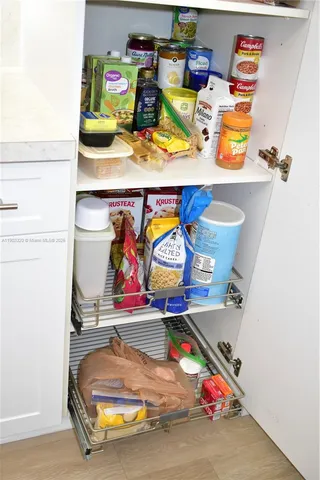 a living room with a flat screen tv and a refrigerator