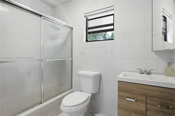 a bathroom with a toilet sink vanity and mirror