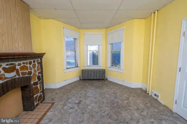 a view of an empty room with a fireplace and a window