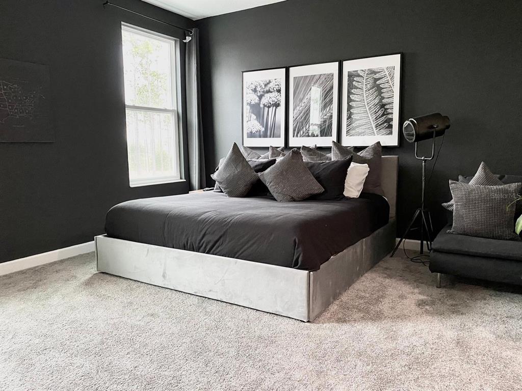 8983 Backswing Way Davenport, FL 33896 - Photo 9 of 30 a living room with a bed and a couch