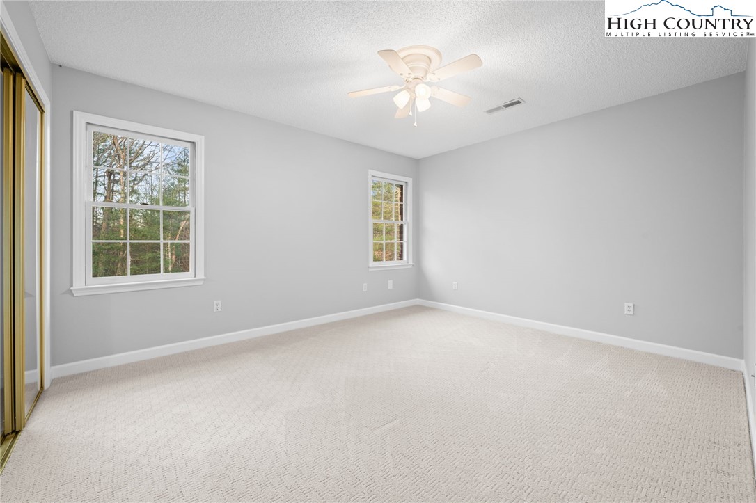 458 Jim Caudill Road Wilkesboro, NC 28697 - Photo 26 of 50 an empty room with windows and chandelier fan