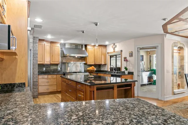a kitchen with stainless steel appliances granite countertop a sink a refrigerator and a stove