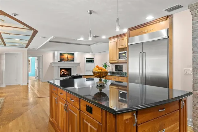 a kitchen with stainless steel appliances granite countertop a sink and cabinets with wooden floor