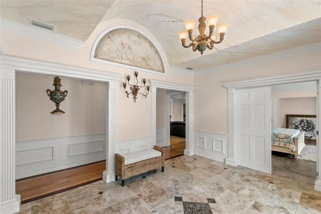 a living room with furniture a chandelier and a table