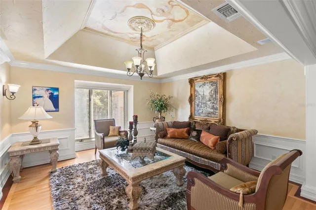 a living room with furniture a chandelier and a window