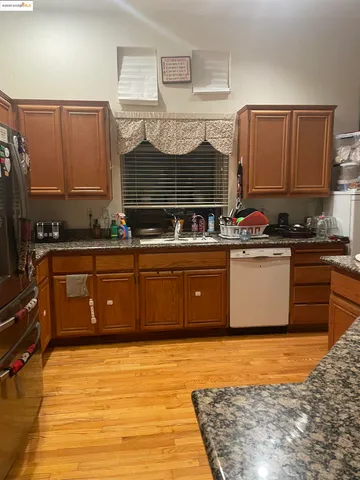 a kitchen with stainless steel appliances a sink counter top space cabinets and a window