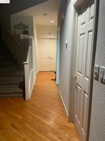a view of a hallway with wooden floor and staircase