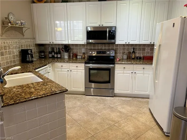 a kitchen with stainless steel appliances granite countertop a stove a sink and a microwave