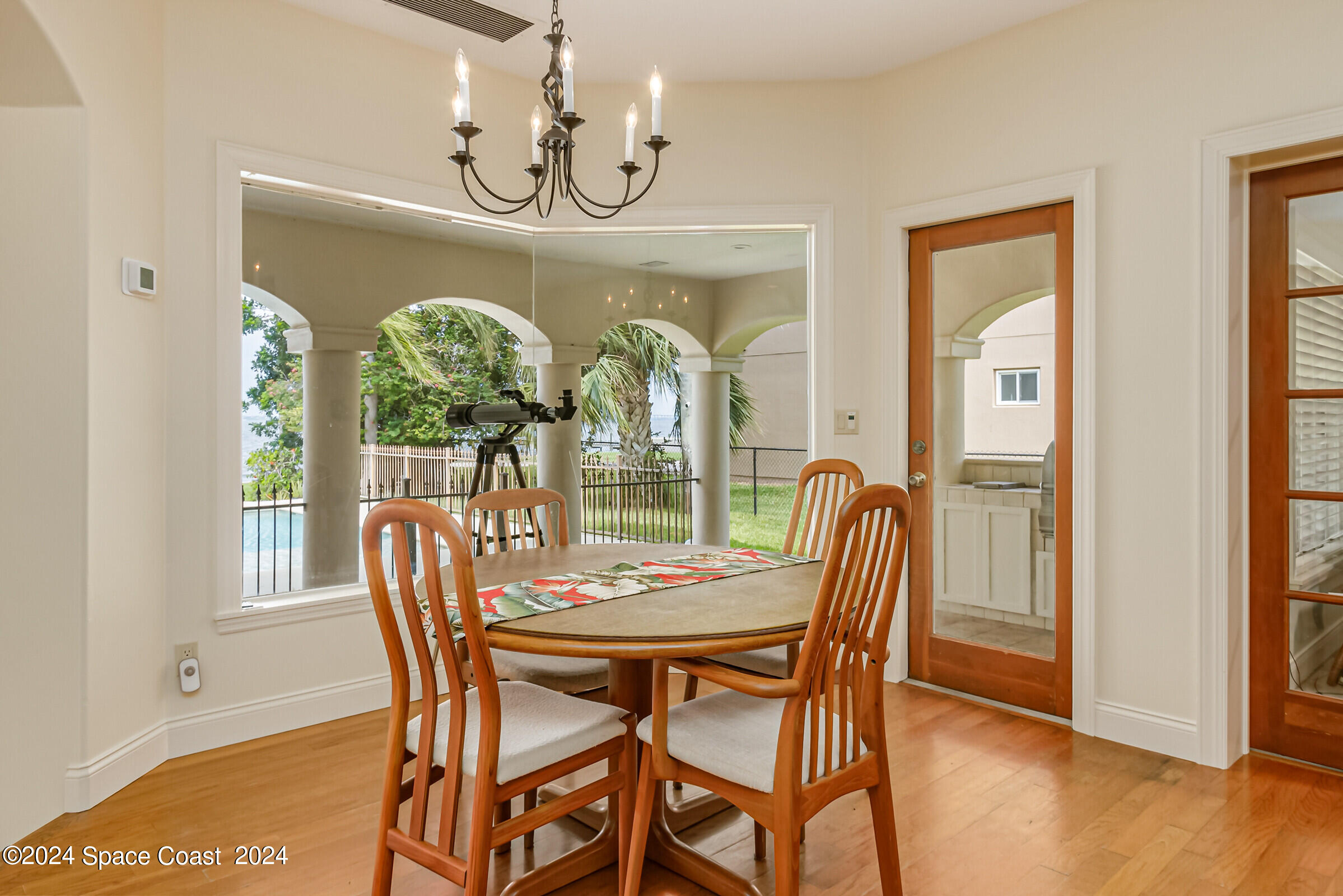 1630 Pine Street Melbourne Beach, FL 32951 - Photo 20 of 54 a dining room with furniture a chandelier and wooden floor