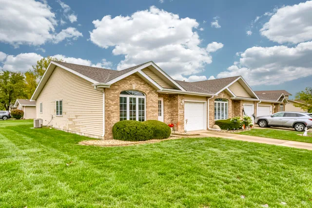 a front view of a house with a yard and garage