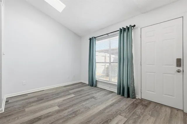 an empty room with wooden floor and a window