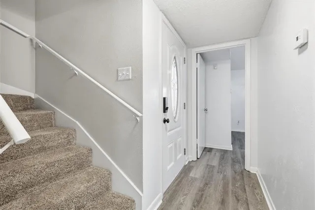 a view of a hallway with wooden floor and entryway