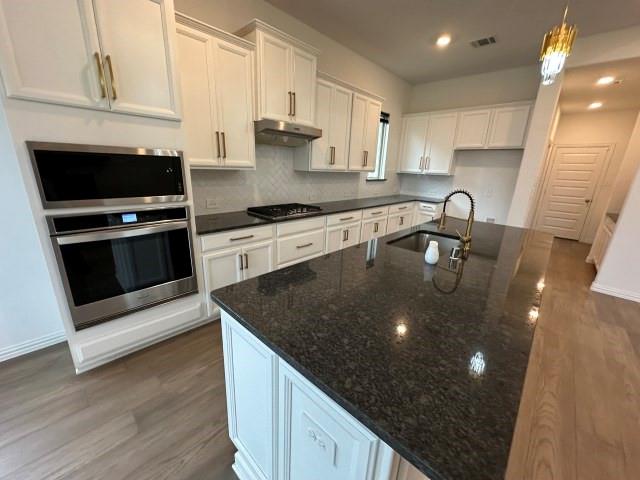 1307 Wheelwright Drive Forney, TX 75126 - Photo 11 of 25 a kitchen with stainless steel appliances granite countertop a sink a stove and a microwave