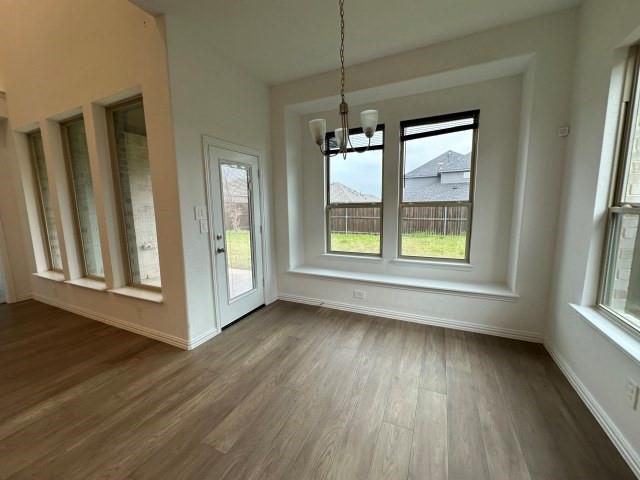 1307 Wheelwright Drive Forney, TX 75126 - Photo 12 of 25 an empty room with wooden floor and windows
