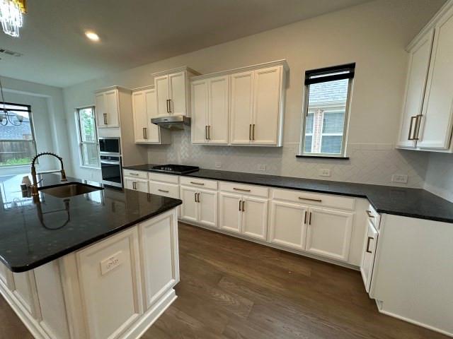 1307 Wheelwright Drive Forney, TX 75126 - Photo 10 of 25 a kitchen with granite countertop a sink a stove and cabinets