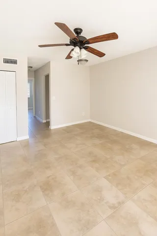 an empty room with a ceiling fan and a window