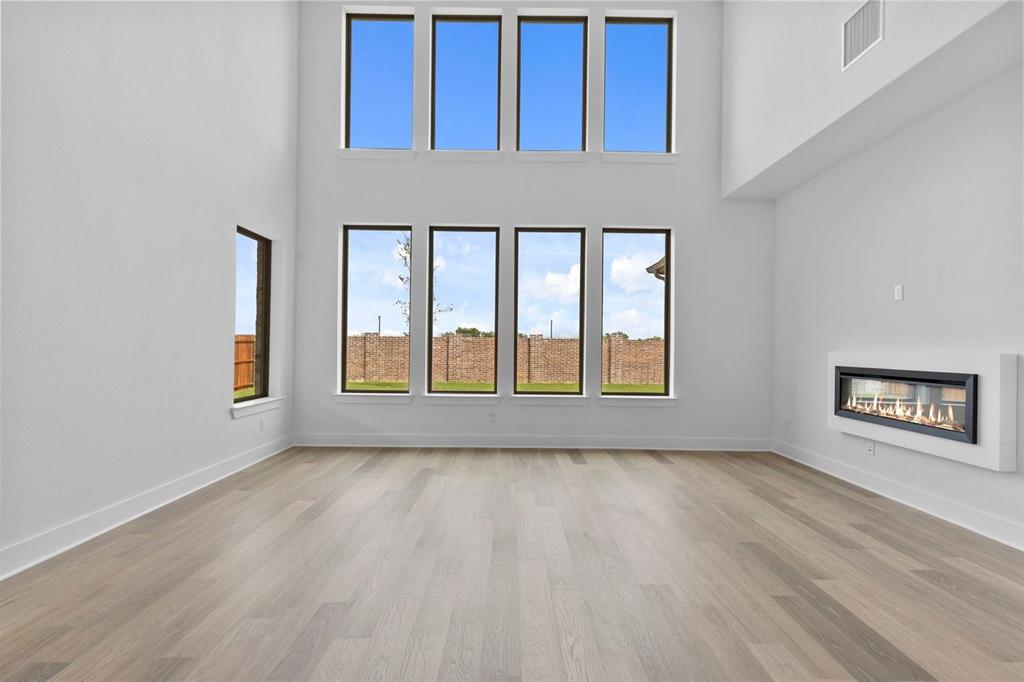 1124 Hitching Post Way Oak Point, TX 75068 - Photo 20 of 34 a view of an empty room with a window and wooden floor