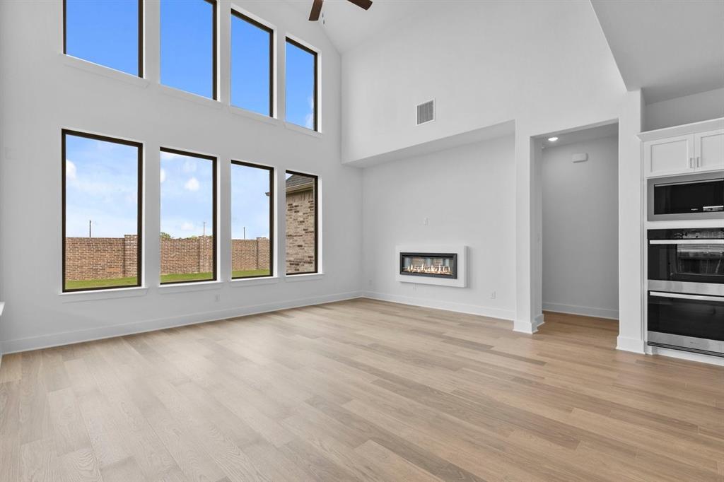 1124 Hitching Post Way Oak Point, TX 75068 - Photo 21 of 34 a view of an empty room with window and wooden floor