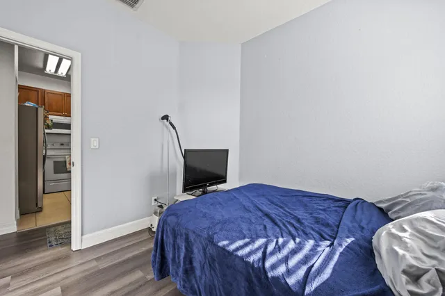 a bed sitting in a bedroom next to a window with pc on the wall
