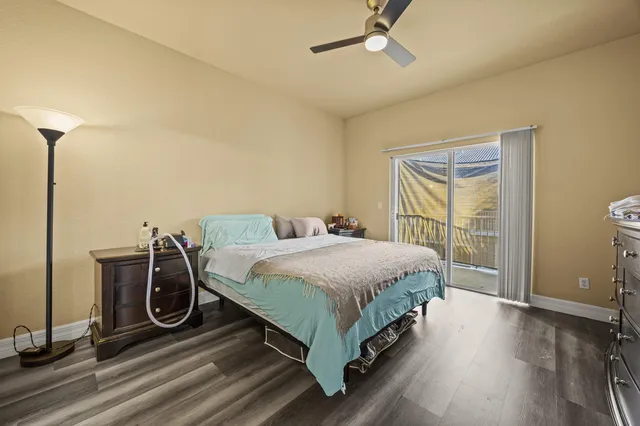 a spacious bedroom with a bed and wooden floor