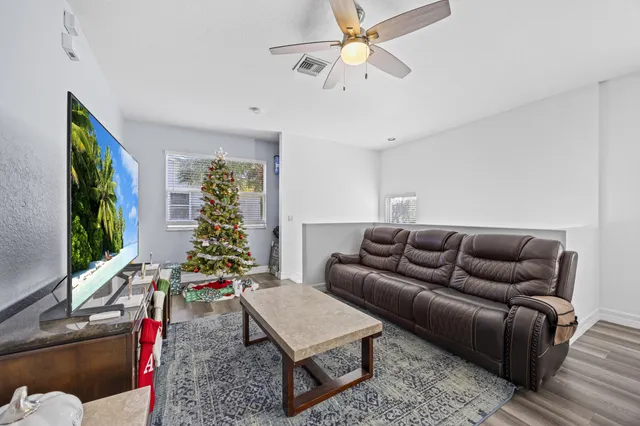 a living room with furniture a flat screen tv and a large window