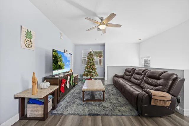 a living room with furniture and a wooden floor