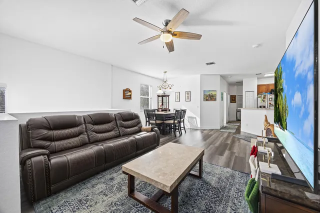 a living room with furniture ceiling fan and a rug