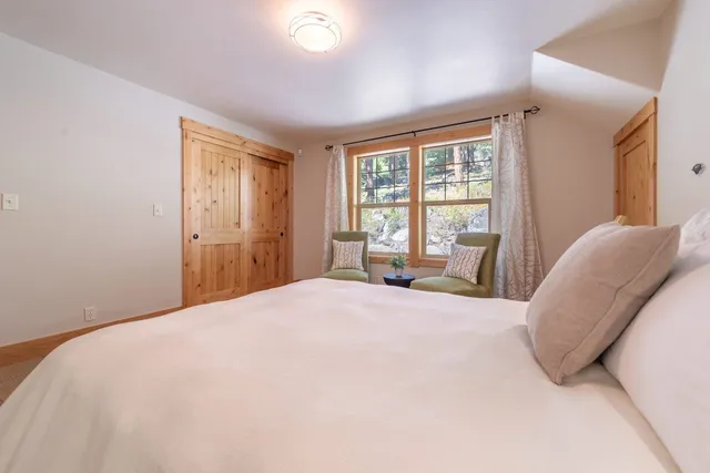 a spacious bedroom with a large bed and a large window