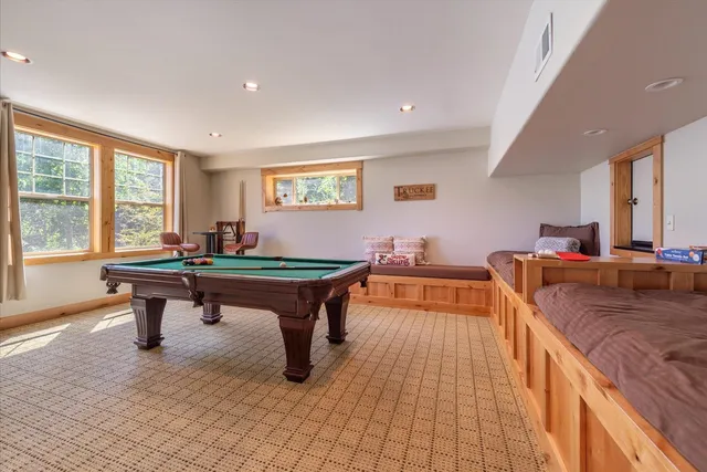 a room with furniture pool table and windows