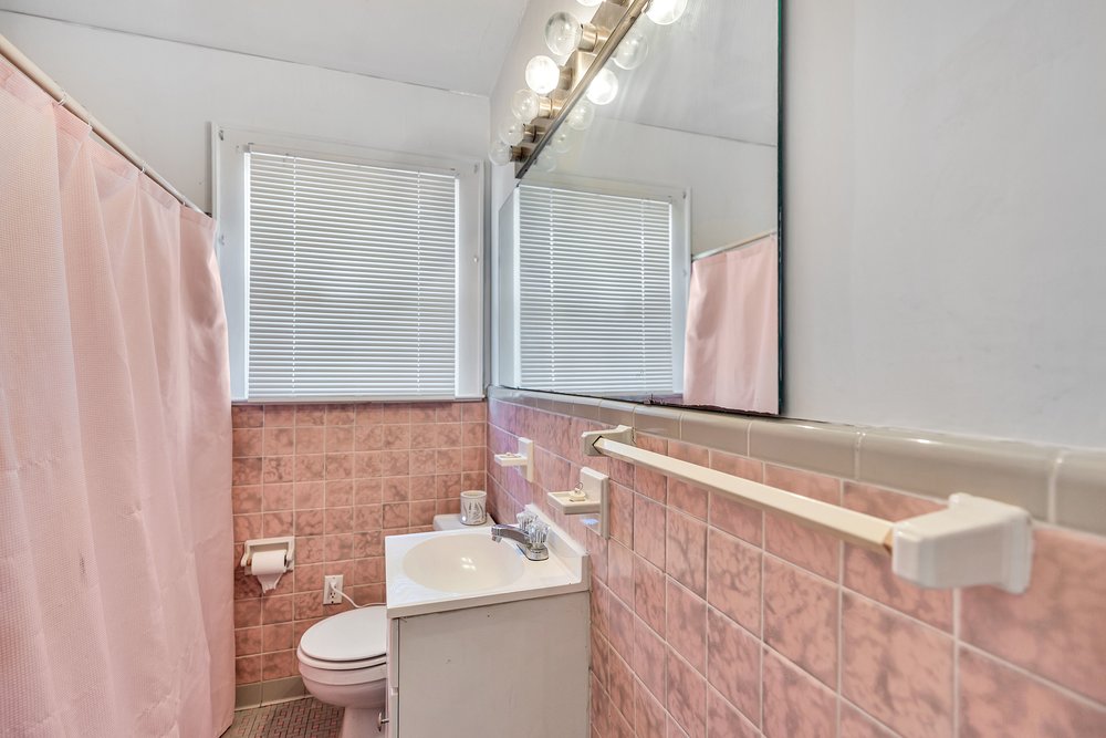 105 West Church Street Iva, SC 29655 - Photo 13 of 25 This bright bathroom features a vanity, mirror, and tiled walls.