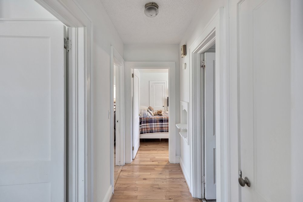 105 West Church Street Iva, SC 29655 - Photo 19 of 25 This bright hallway connects to well-lit rooms with hardwood flooring.