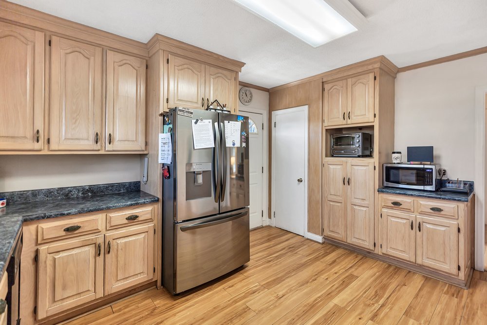 105 West Church Street Iva, SC 29655 - Photo 2 of 25 This spacious kitchen offers ample storage, bright lighting, and wood-like flooring.