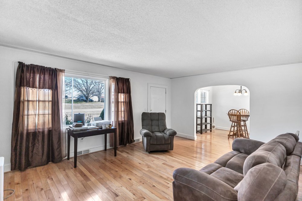 105 West Church Street Iva, SC 29655 - Photo 3 of 25 This light-filled living area features warm hardwood flooring, providing a welcoming ambiance.