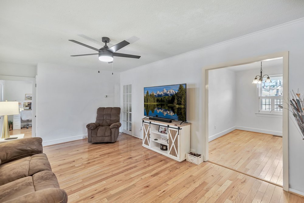 105 West Church Street Iva, SC 29655 - Photo 10 of 25 Bright and airy living area featuring rich hardwood flooring and a stylish ceiling fan.
