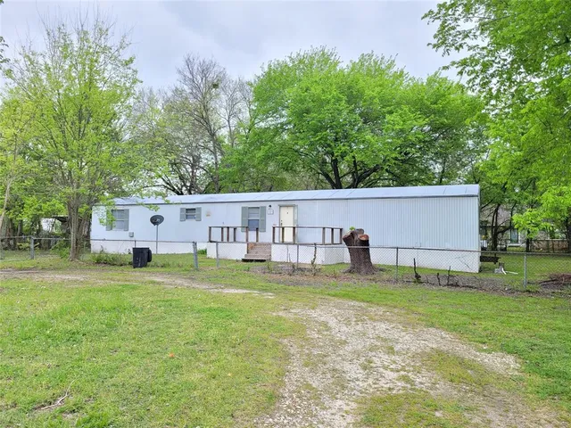 a view of a house with a big yard and a large tree