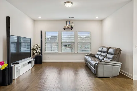 a living room with furniture wooden floor and a flat screen tv