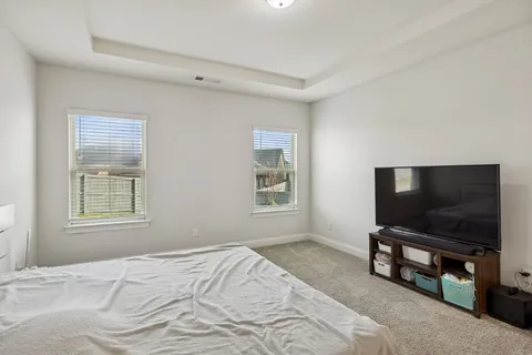 a bedroom with window and flat screen tv