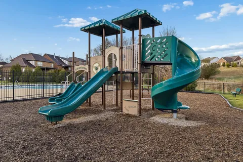 a view of a tennis ground with large trees