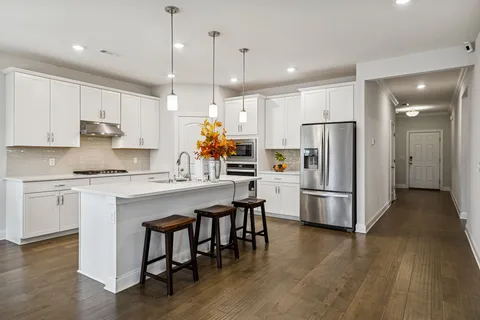 a kitchen with kitchen island a white counter space stainless steel appliances and cabinets