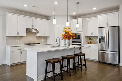 a kitchen with refrigerator a sink and chairs