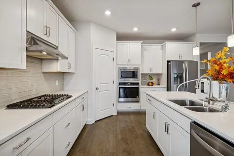 a kitchen with stainless steel appliances granite countertop a sink stove and refrigerator