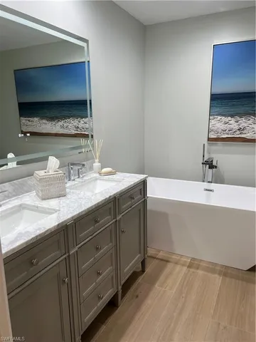 a bathroom with a double vanity sink mirror and bathtub