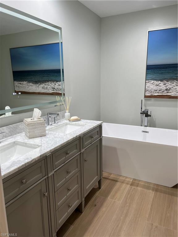 901 Egrets Run, Unit 4102 Naples, FL 34108 - Photo 20 of 27 a bathroom with a double vanity sink mirror and bathtub