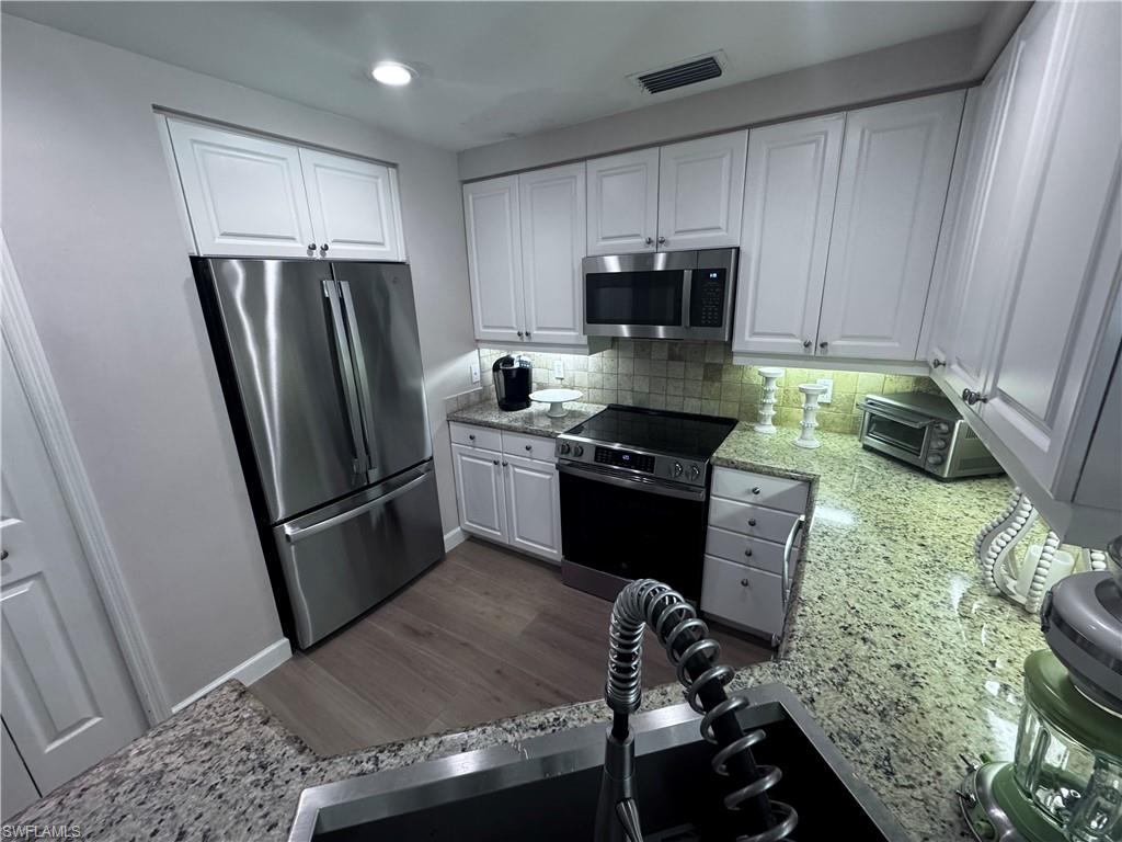 901 Egrets Run, Unit 4102 Naples, FL 34108 - Photo 26 of 27 a kitchen with a refrigerator stove and microwave