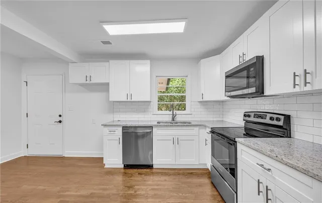 an empty room with wooden floor and potted plant