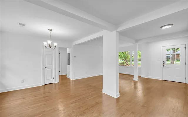 a view of empty room with wooden floor and window