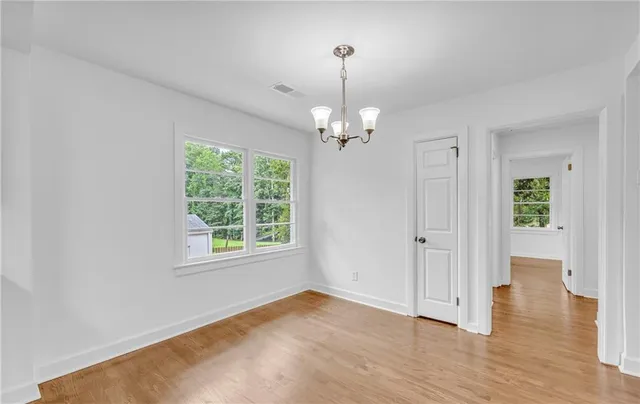a view of a kitchen with a sink dishwasher a stove top oven with wooden floor