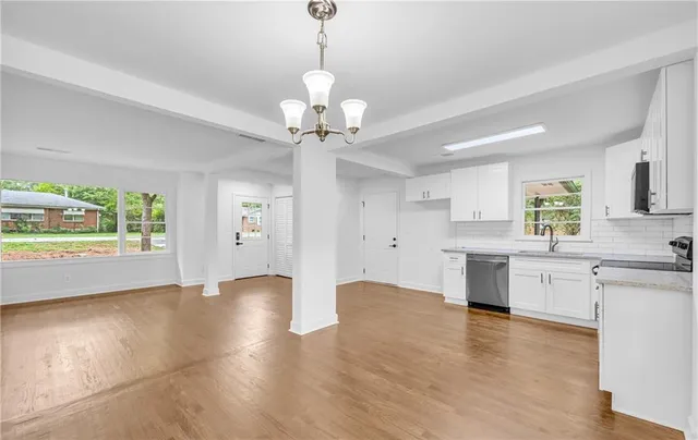 a view of a hallway with wooden floor and closet