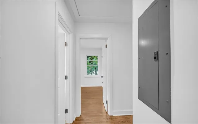 a view of a hallway with wooden floor and stairs